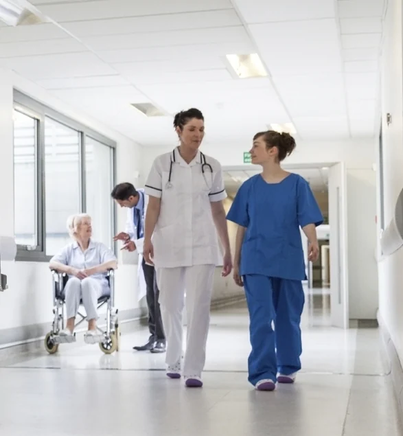 Profissionais de saúde a acompanhar uma pessoa num corredor hospitalar